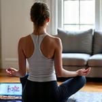 Personne faisant du yoga à la maison avec une tablette